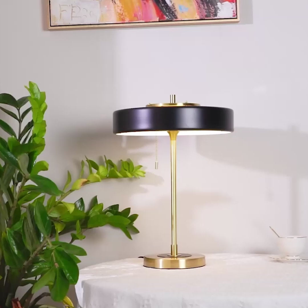 Fester Table Lamp  A warm glow radiates from within as light escapes through an opal diffuser atop it.