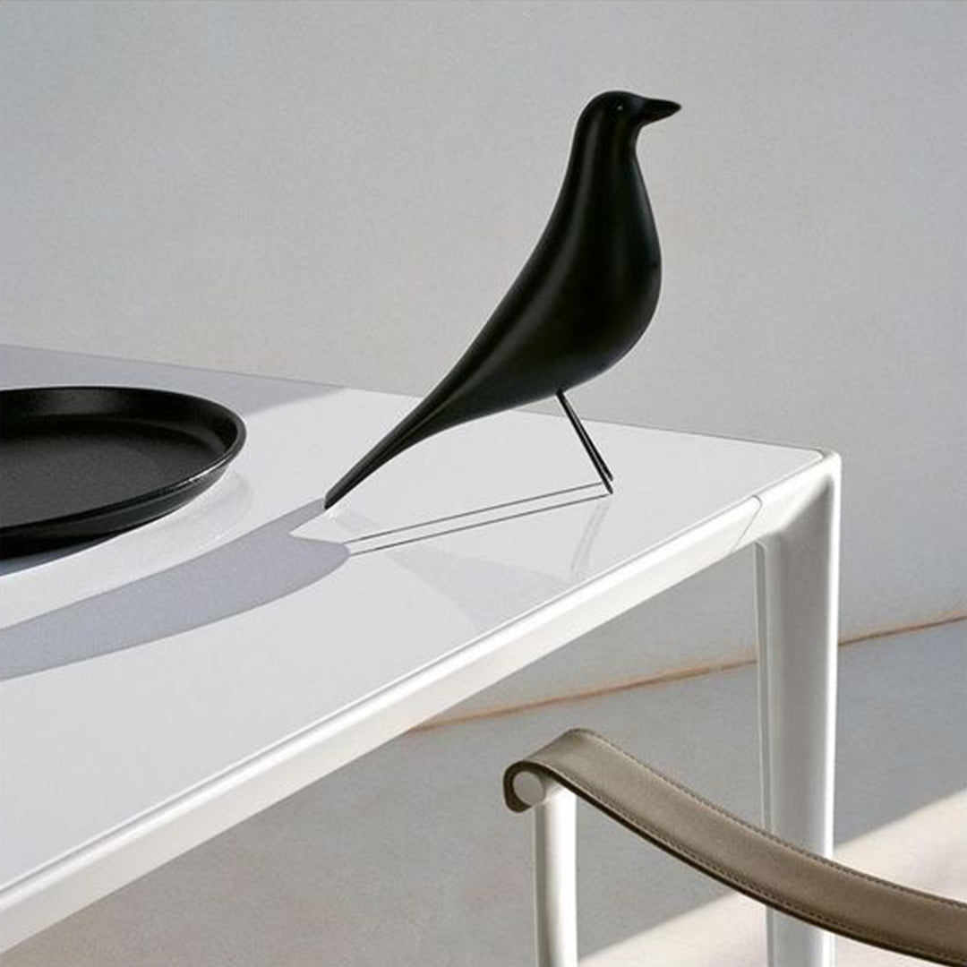 House Bird this painted wooden bird stands with its black body on display.